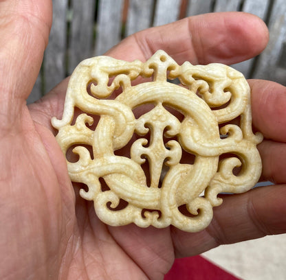 A Chinese Hardstone Disc Pendant Carving of two entwined dragons 7cm Across