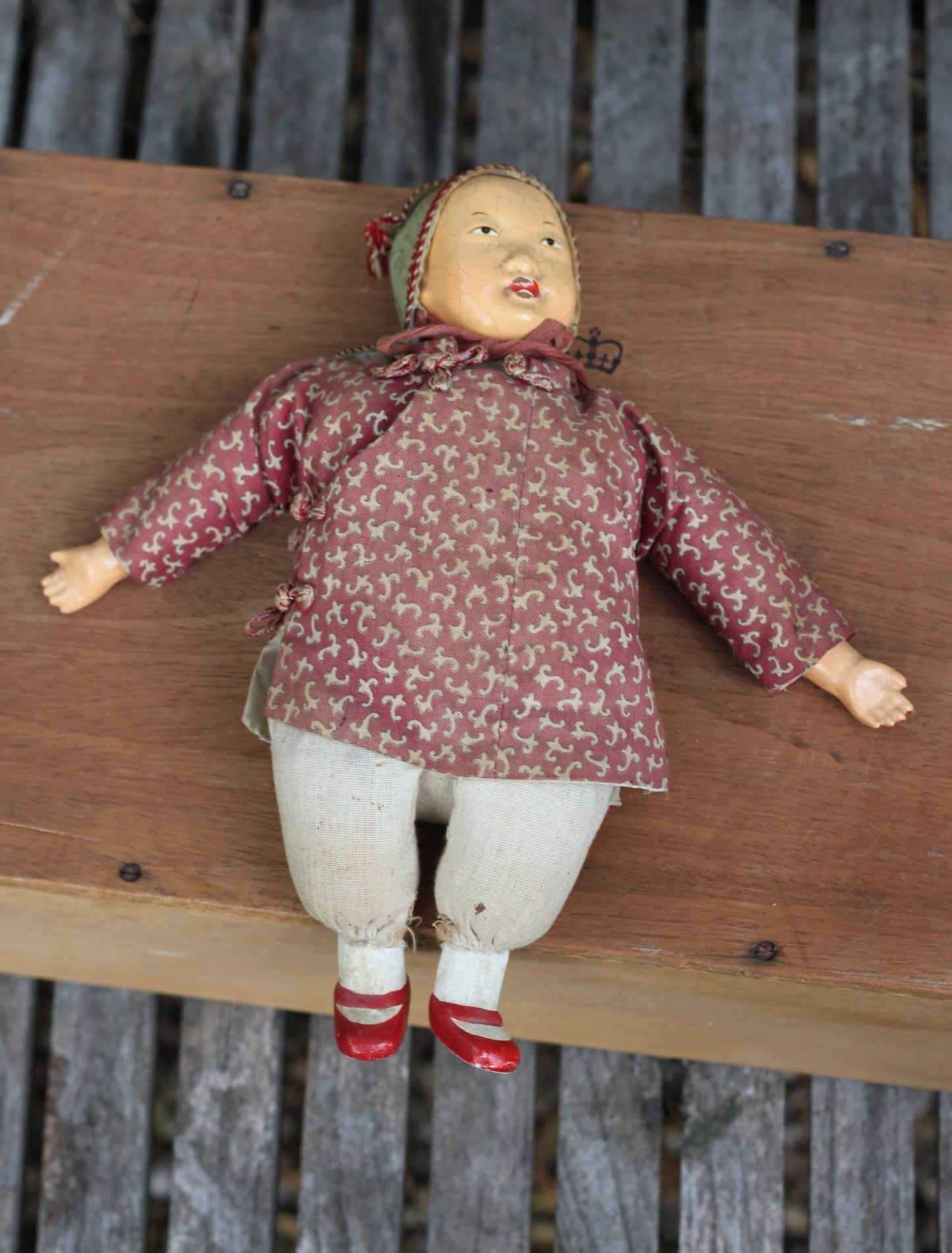 An early 20th century Chinese lacquered doll with cloth body, 24cm high