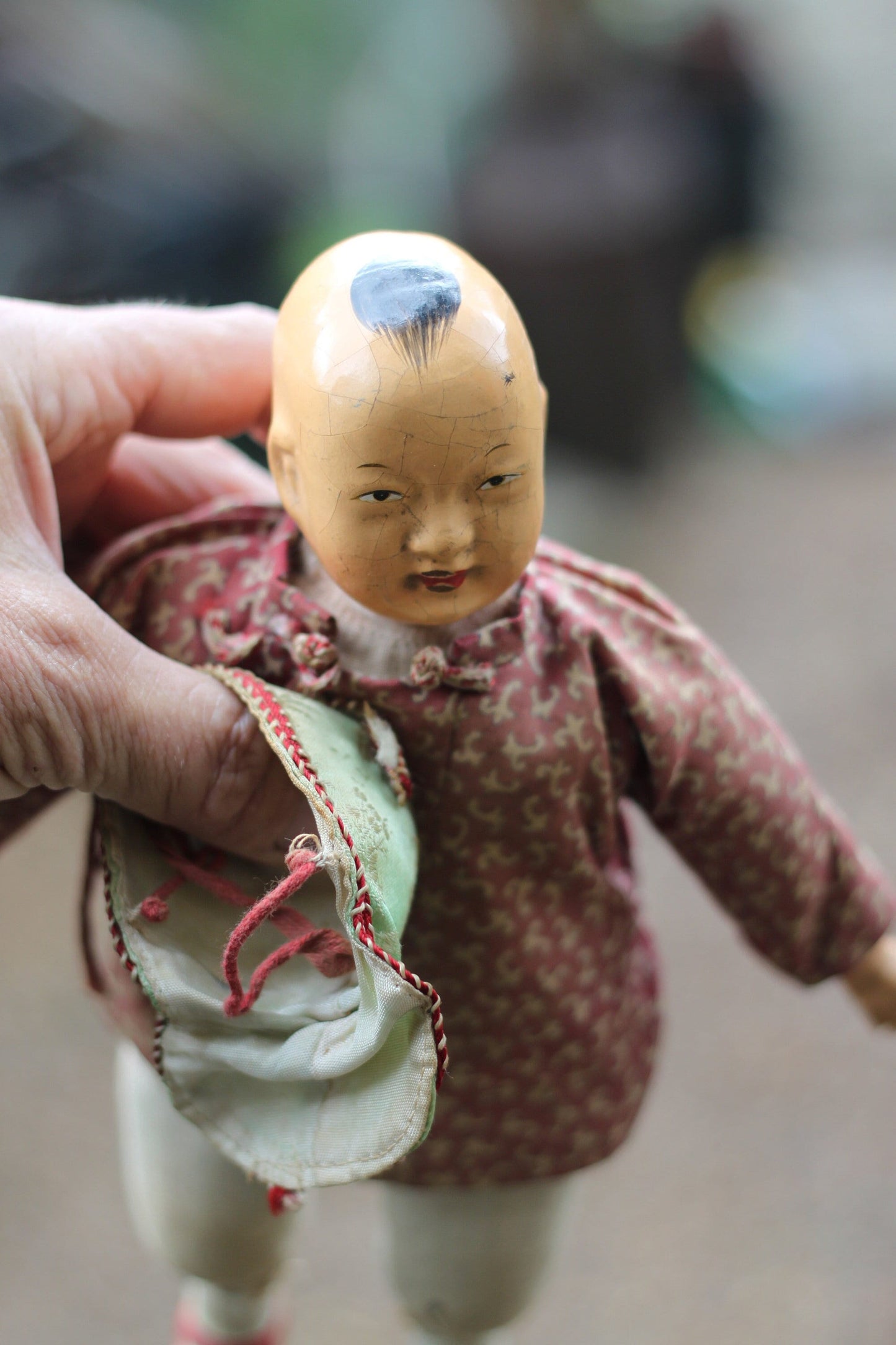 An early 20th century Chinese lacquered doll with cloth body, 24cm high