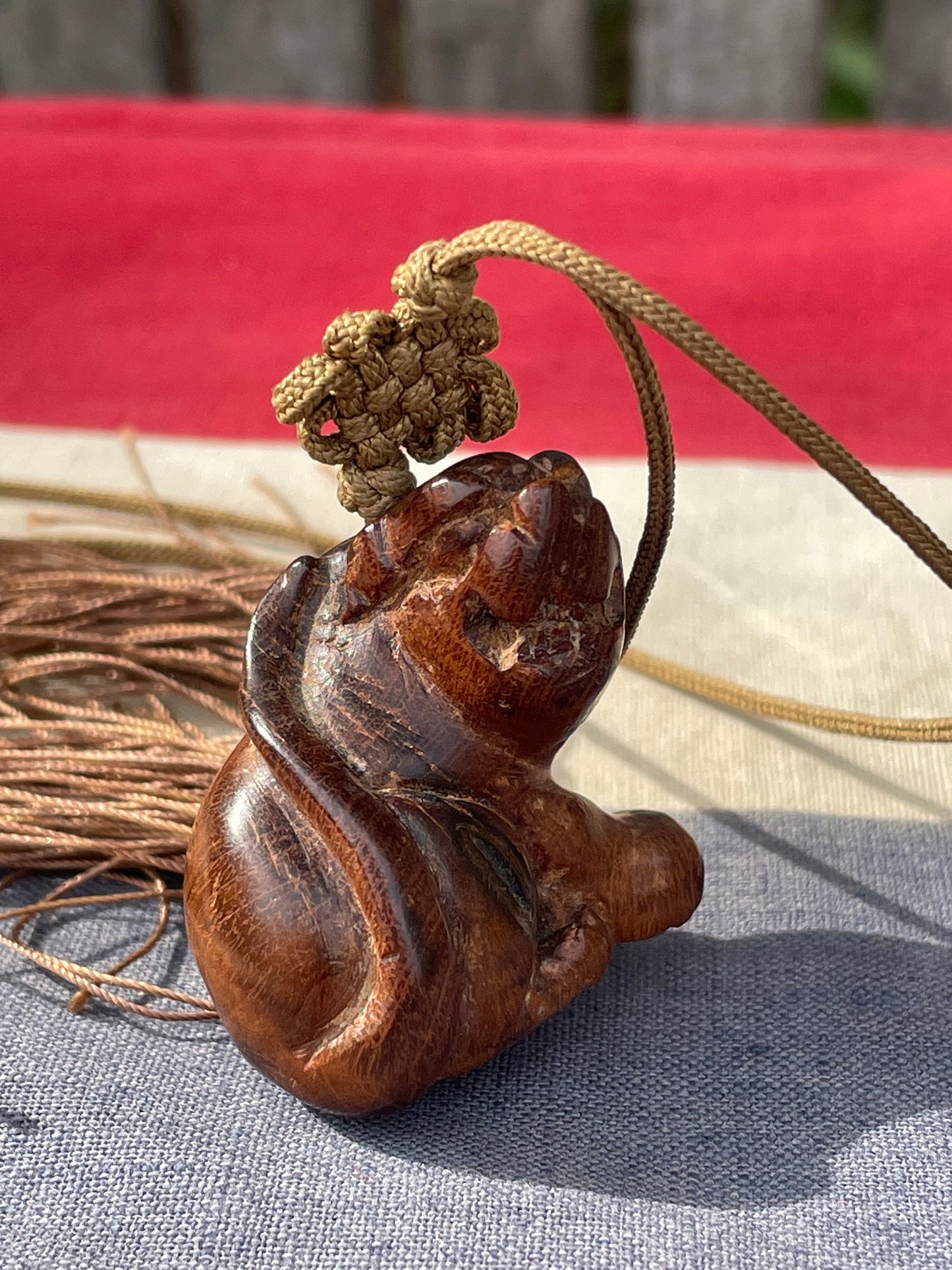 A Hand Carved Hard Wood Dress Toggle of a Chinese Foo Dog on a Silk Cord 4cm Long