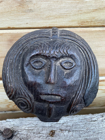 A 17th Century Carved Oak Folk Art Roundel Depicting a Long Haired Man, Diameter 12cm.