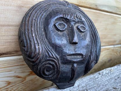 A 17th Century Carved Oak Folk Art Roundel Depicting a Long Haired Man, Diameter 12cm.