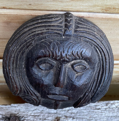 A 17th Century Carved Oak Folk Art Roundel Depicting a Long Haired Man, Diameter 12cm.