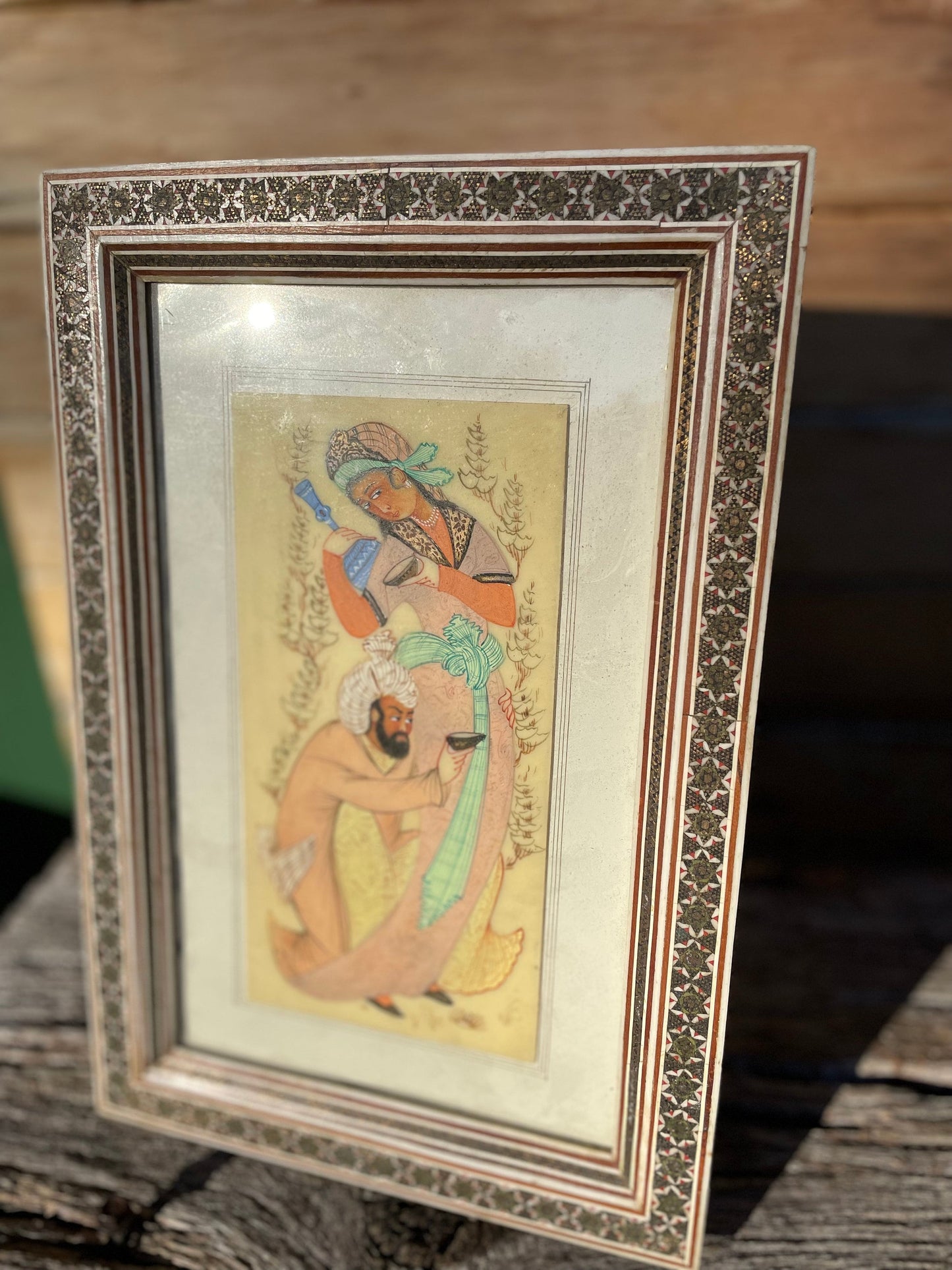 A Persian Hand Painted Panel With two Figures Housed in a Vizagapatam Style Easel Frame  31.5cm Tall