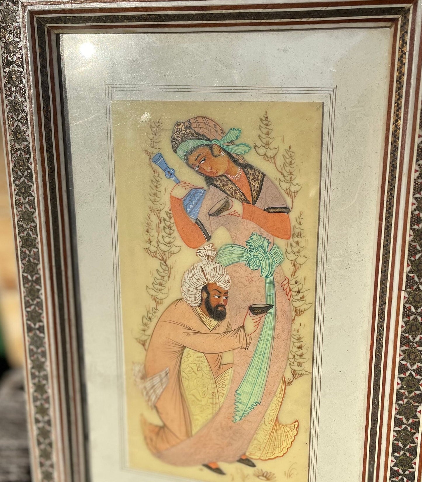 A Persian Hand Painted Panel With two Figures Housed in a Vizagapatam Style Easel Frame  31.5cm Tall