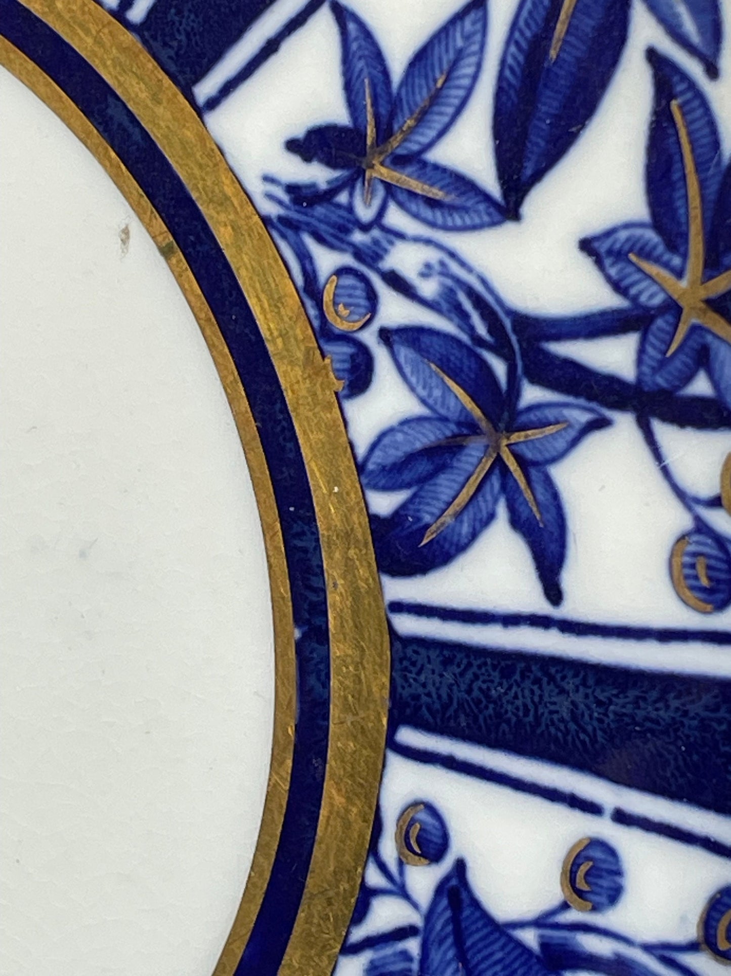 A Victorian hand painted ceramic plate from 1875 with a blue and gold floral design 24cm diameter