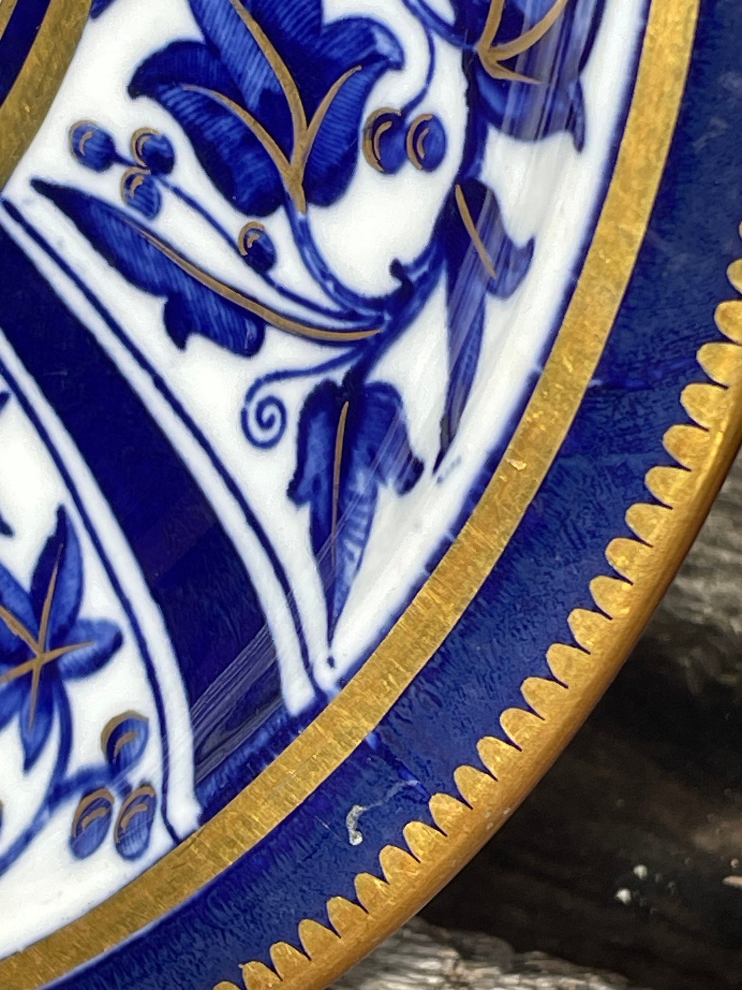 A Victorian hand painted ceramic plate from 1875 with a blue and gold floral design 24cm diameter