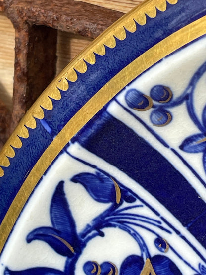 A Victorian hand painted ceramic plate from 1875 with a blue and gold floral design 24cm diameter