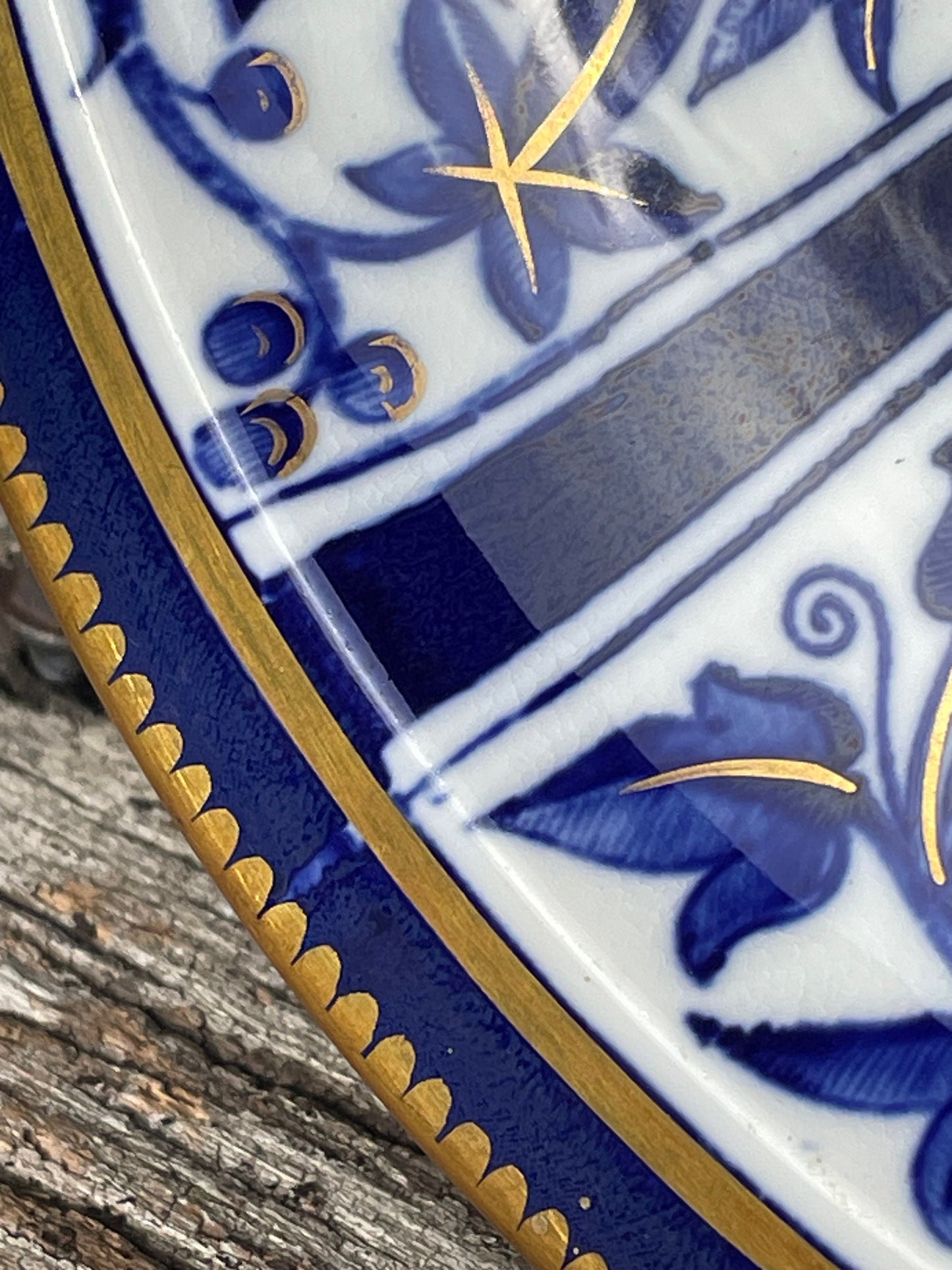 A Victorian hand painted ceramic plate from 1875 with a blue and gold floral design 24cm diameter