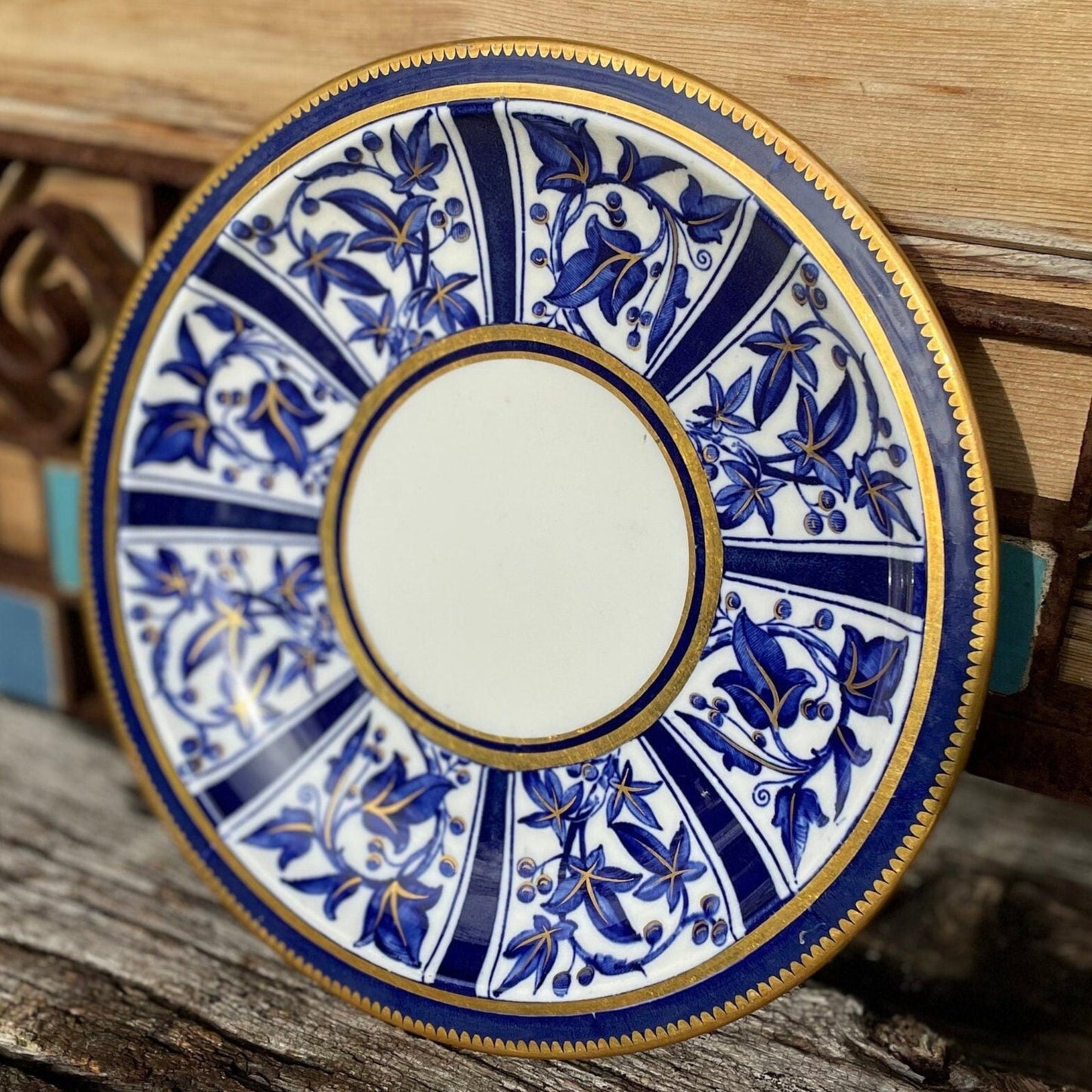 A Victorian hand painted ceramic plate from 1875 with a blue and gold floral design 24cm diameter