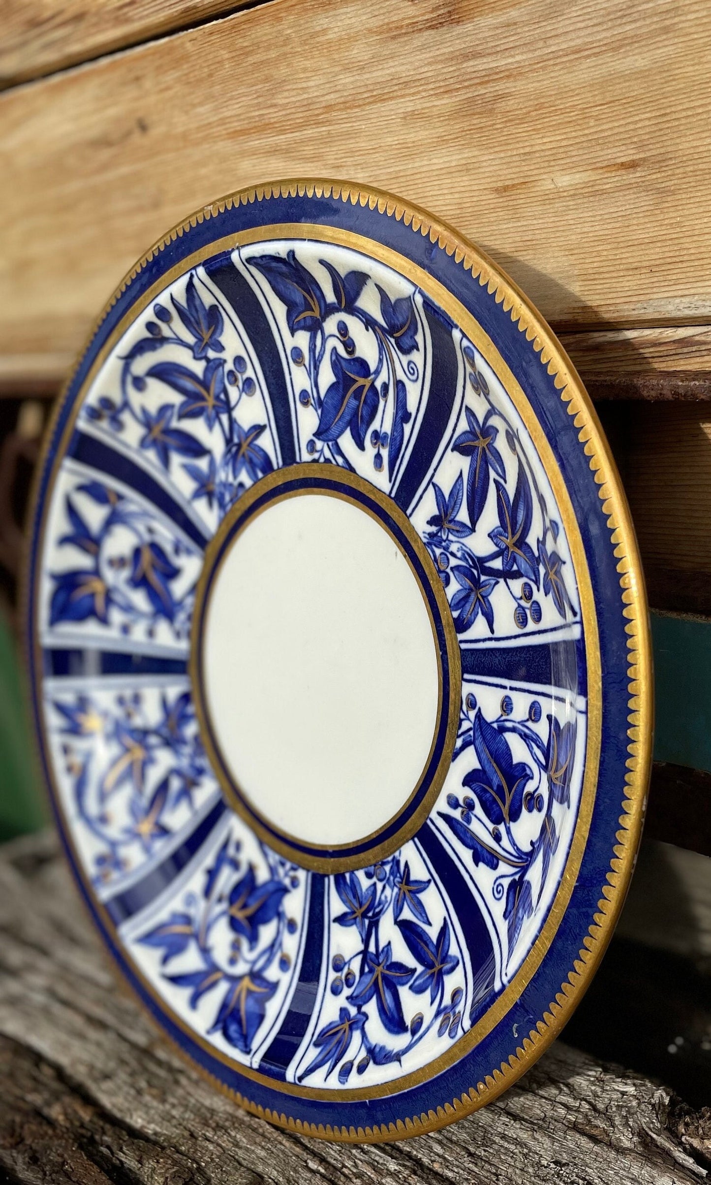 A Victorian hand painted ceramic plate from 1875 with a blue and gold floral design 24cm diameter