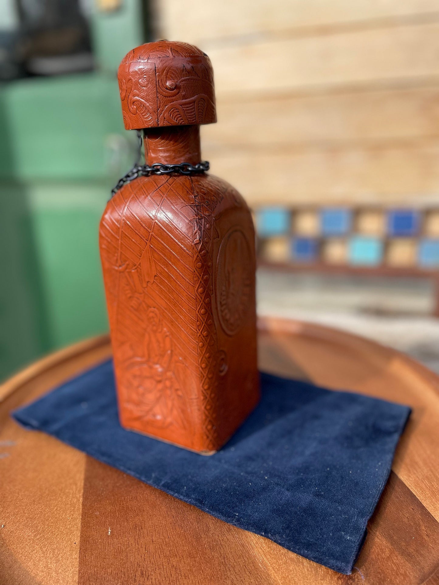 A vintage leather bound decanter with embossed imagery of Don Quixote author Miguel de Cervantes and Spanish text 27cm tall