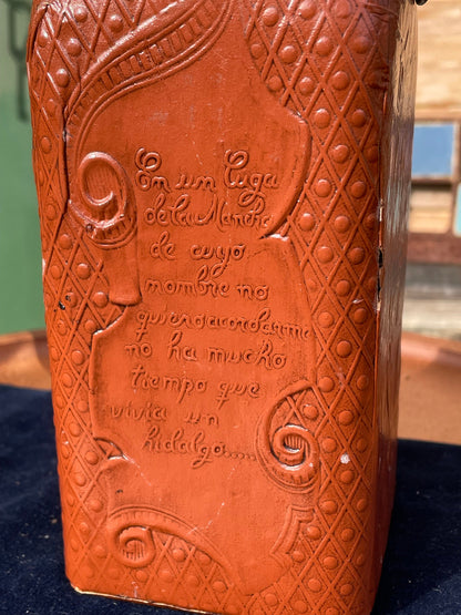 A vintage leather bound decanter with embossed imagery of Don Quixote author Miguel de Cervantes and Spanish text 27cm tall