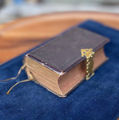 A burgundy leather bound antique Church Services common prayer book with gilt metal fastener 184