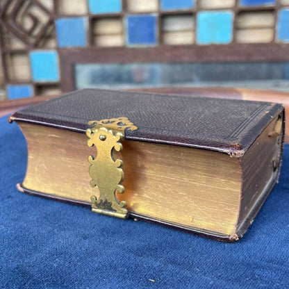 A burgundy leather bound antique Church Services common prayer book with gilt metal fastener 184