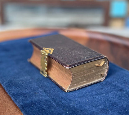 A burgundy leather bound antique Church Services common prayer book with gilt metal fastener 184