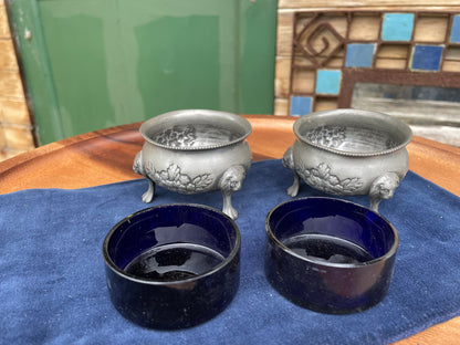 A pair of antique pewter salts with Bristol blue glass liners and lion feet 6.5cm diameter