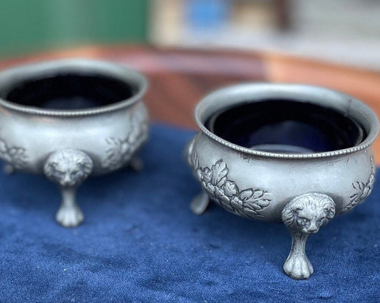 A pair of antique pewter salts with Bristol blue glass liners and lion feet 6.5cm diameter