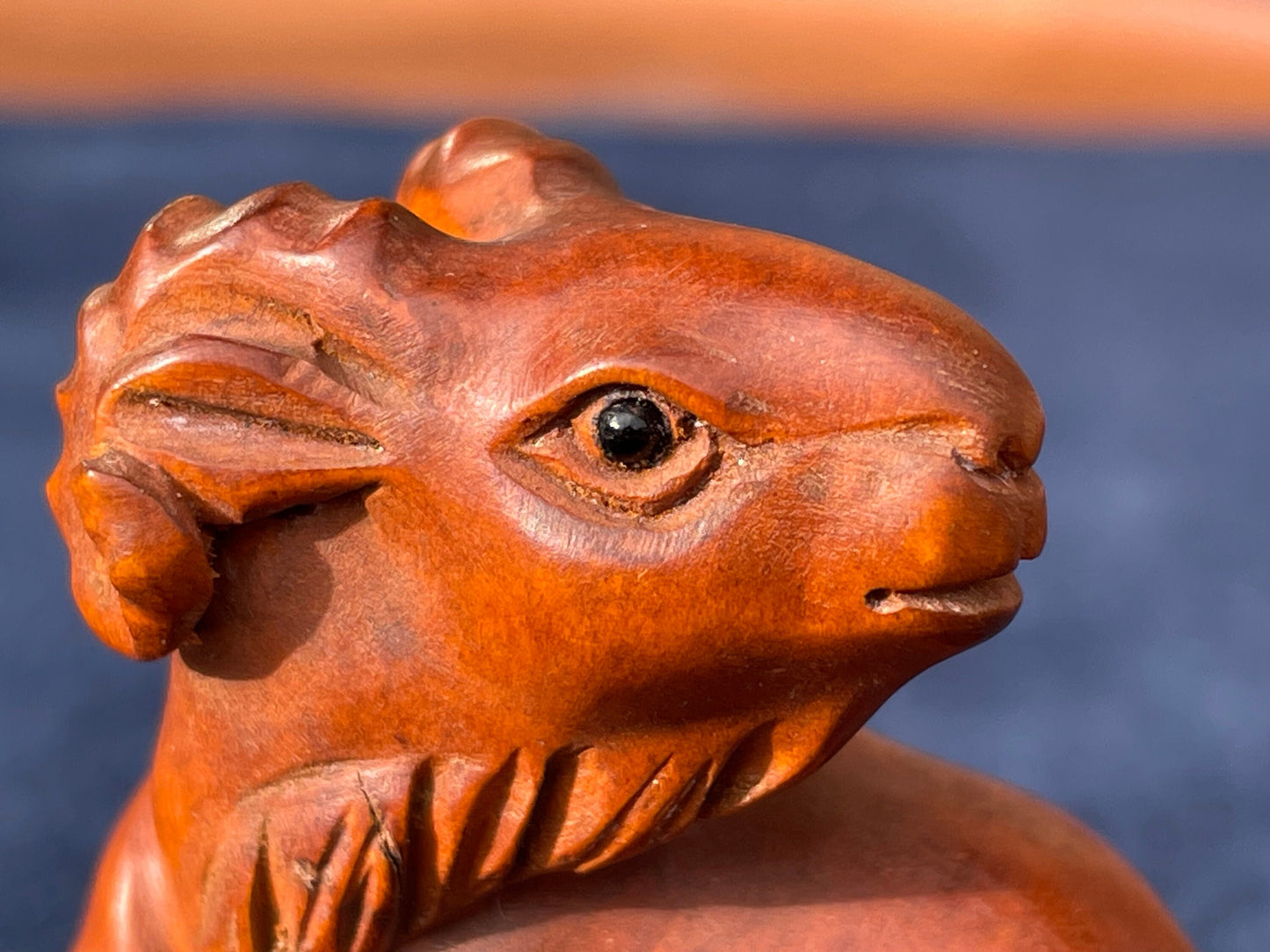 A  Japanese hardwood hand carved Ram netsuke with glass eyes 5cm tall