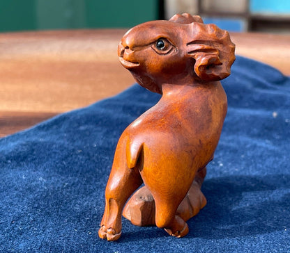 A  Japanese hardwood hand carved Ram netsuke with glass eyes 5cm tall