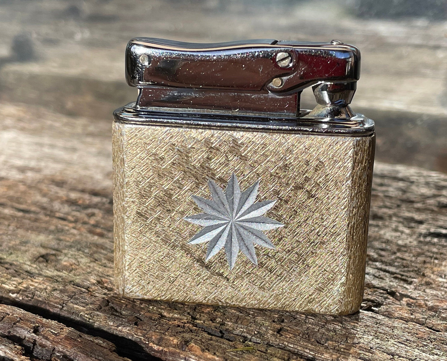 A vintage Colibri fuel lighter engraved with a star motif  4.5cm wide