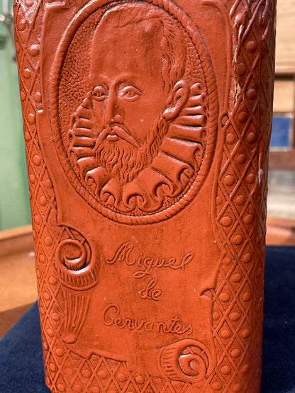 A vintage leather bound decanter with embossed imagery of Don Quixote author Miguel de Cervantes and Spanish text 27cm tall