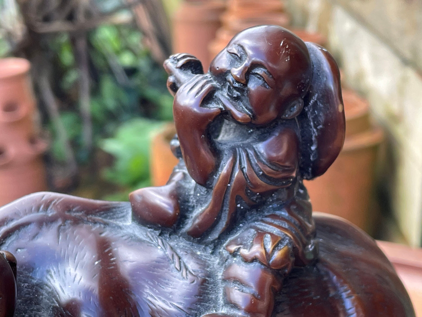 A Chinese ceramic figure of a water buffalo carrying a young monk/boy playing a flute 15cm tall