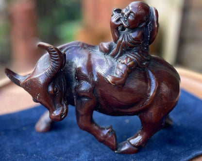 A Chinese ceramic figure of a water buffalo carrying a young monk/boy playing a flute 15cm tall