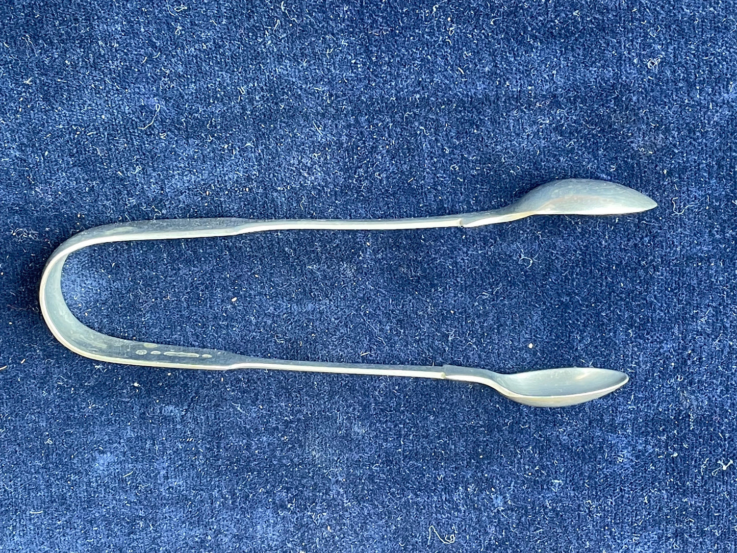 A  pair of silver plate sugar tongs by Pinder Bros 11.5cm long